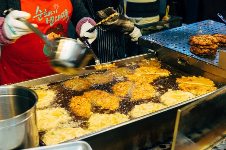 A person frying hash browns in a grease trap
